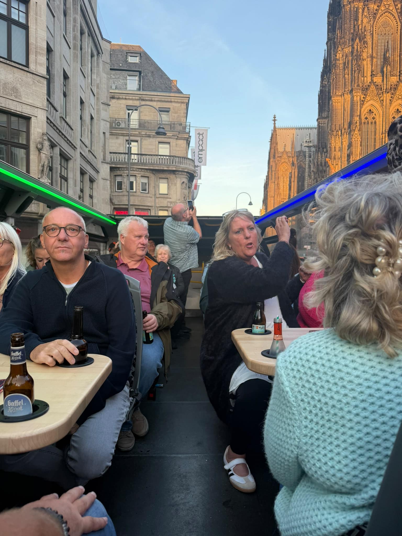 Kölsch-Tourbus Gäste an den Tischen auf dem Oberdeck bei einer Bustour durch Köln