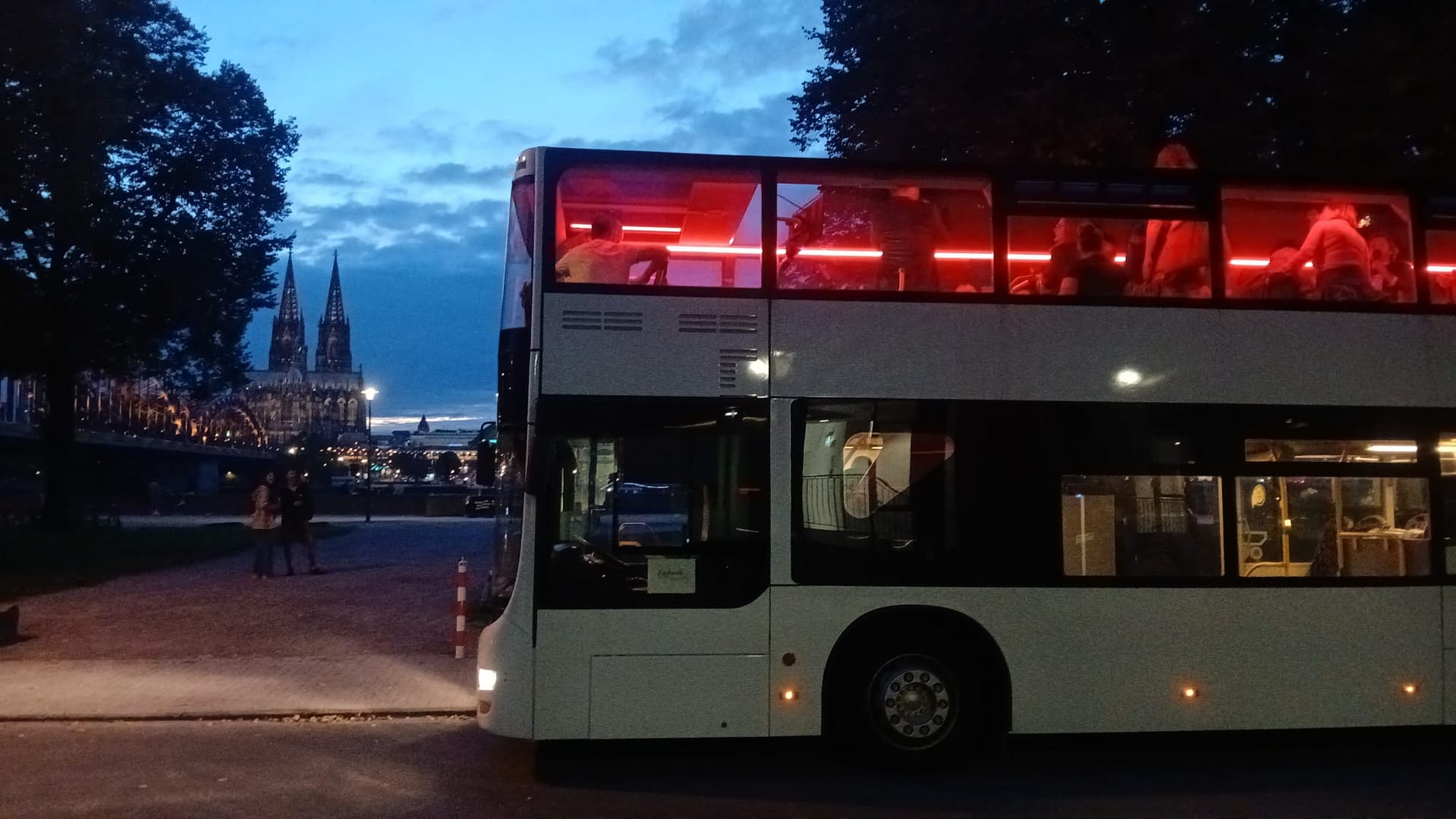 Kölsch-Tourbus Kölsch Doppeldecker mit beleuchtetem Oberdeck am Abend