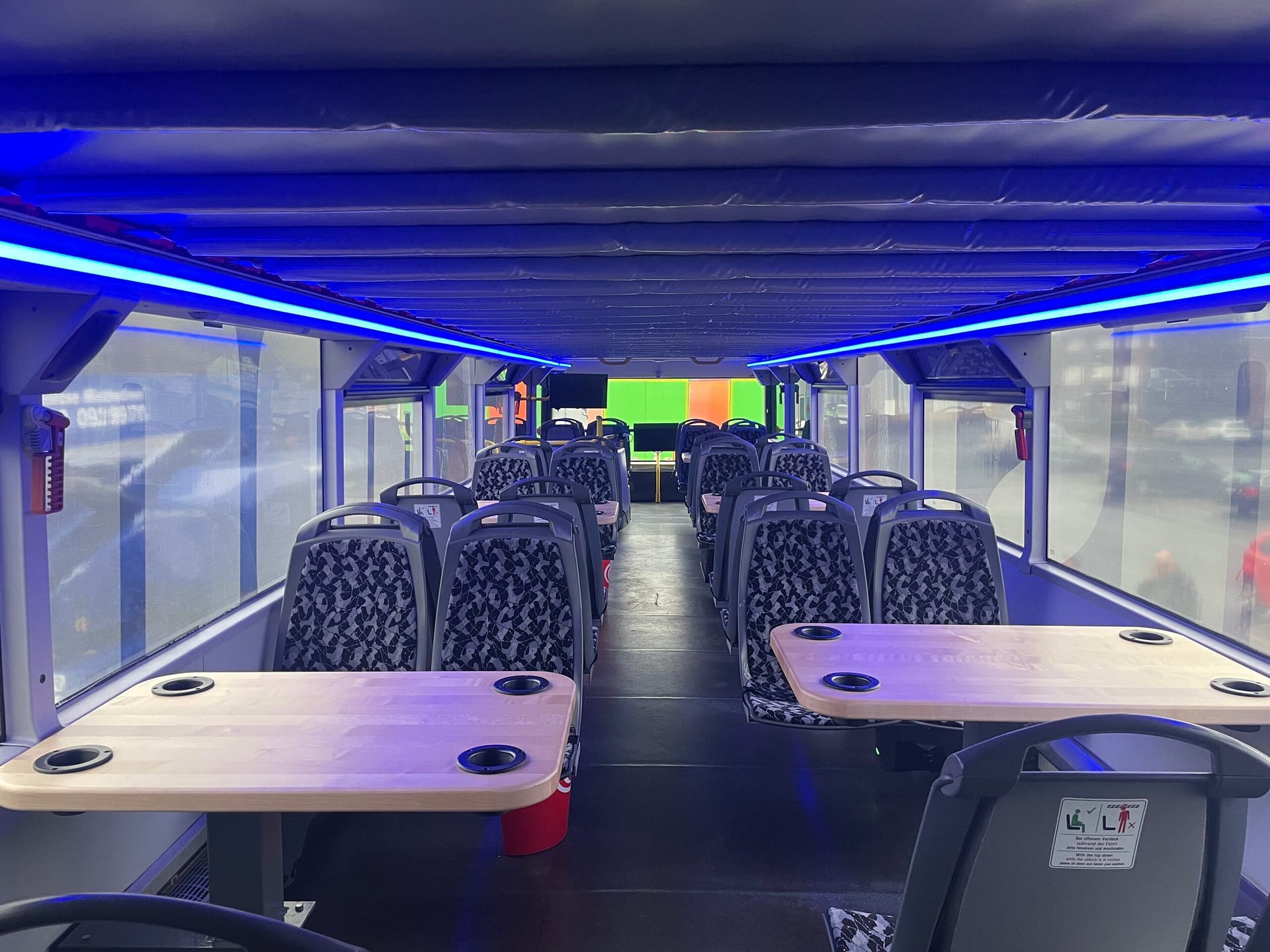 Home Innenraum des Kölsch Tourbusses mit Tischen und blauer Deckenbeleuchtung